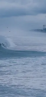 Ocean waves with a cloudy blue sky in the background, creating a serene atmosphere.