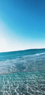 Crystal clear ocean waves under blue sky.