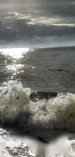 Ocean waves crashing under a cloudy sky with sun reflection.