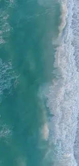 Serene aerial view of ocean waves crashing on a beach.