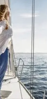 Woman standing on yacht, gazing at the tranquil ocean under a clear sky.