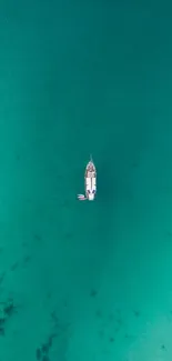 Aerial view of a yacht on calm turquoise waters.