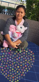 Person sitting with plush toys on outdoor furniture by the waterside.