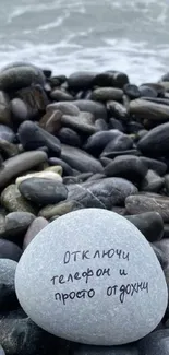 Pebble beach with message on stone against ocean backdrop, serene and calming.