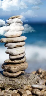 Stack of pebbles balancing on a beach with ocean background.