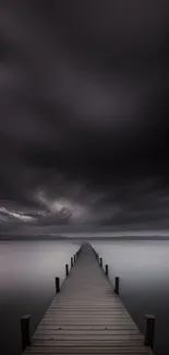 Dramatic sky above serene pier stretching into calm water.