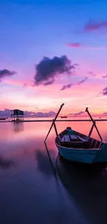 Serene pink sunset over a tranquil lake with a still boat.
