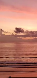 Pink sunset over the ocean with calm waves and clouds.