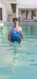 Man standing in the pool with a serene backdrop.