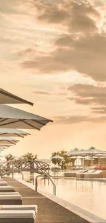 Serene view of poolside at sunset with umbrellas and loungers.