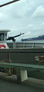 Calm dock scene with a ship and cloudy skies.