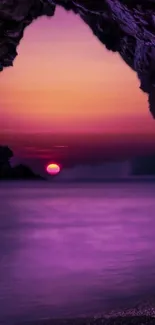 Purple sunset over ocean seen from a rocky cave opening.