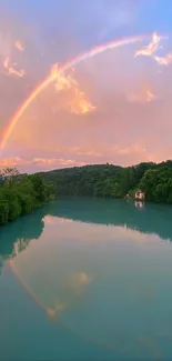 Scenic view of a rainbow over a tranquil lake with greenery.