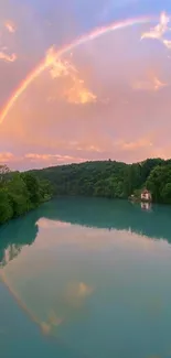 A serene rainbow arches over a tranquil lake with a pastel sky reflection.