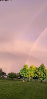 Double rainbow above a lush park with airplane in pastel sky.