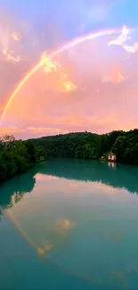 Rainbow arcs over tranquil lake under a vibrant sky.