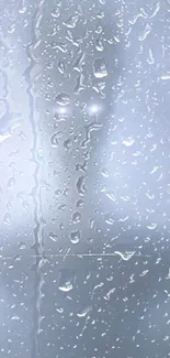 Rain drops on glass with soft gray and blue hues, creating a tranquil wallpaper.