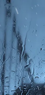 Rain drops on a clear glass create a tranquil blue view.