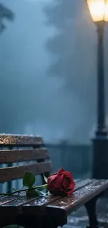 A rose on a wet bench under a lamppost on a rainy night.