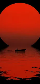 Red sun setting over calm water with boat silhouette.