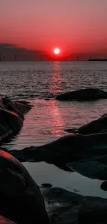 Beautiful red sunset over sea with rocky foreground.