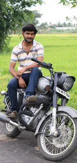 Man on motorcycle in lush green field background.