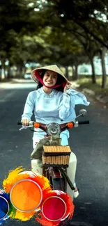 Woman riding bicycle on calm, tree-lined road with colorful design.