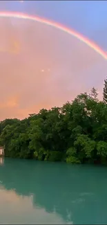 Serene river with lush greenery and a vibrant rainbow in the sky.