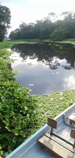 River with lush greenery and boat, reflecting a cloud-filled sky.