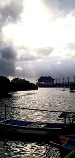 Serene river sunset with boats and a cloudy sky