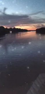 Serene sunset over a calm river with a dark blue sky reflecting on the water.