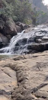 A peaceful rocky waterfall surrounded by greenery.