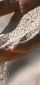 Sand flowing through hands, capturing serenity.