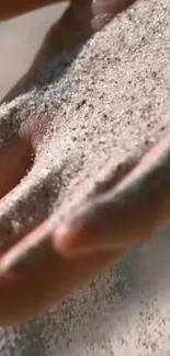 Close-up of sand flowing gently through a hand, creating a calming and natural image.