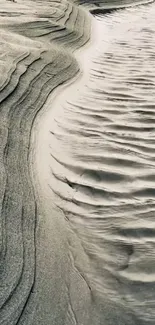 Elegant sand patterns forming natural waves in a calming gray tone.