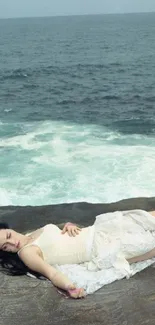 Person relaxing on rocky coast by the sea.