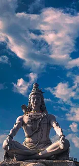 Lord Shiva sculpture under a cloudy blue sky.