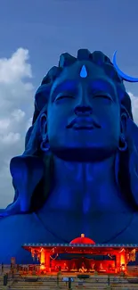 Blue Shiva statue with sky background.