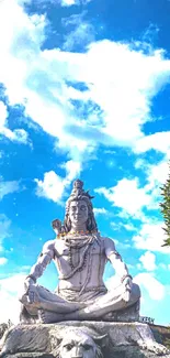 Lord Shiva statue under a vibrant blue sky with fluffy clouds.