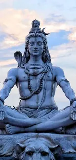 Shiva statue in meditation against a calm sky backdrop, perfect for mobile wallpaper.