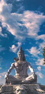 Serene Shiva statue under blue sky with clouds.