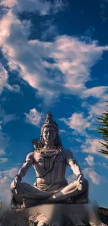Statue of Shiva against a blue sky backdrop.