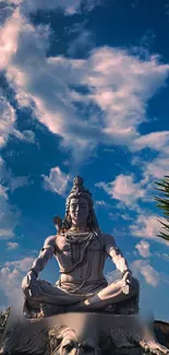 Shiva statue beneath a blue sky with clouds, capturing serenity and peace.