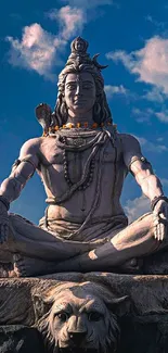 Statue of Lord Shiva under a vibrant blue sky with clouds.