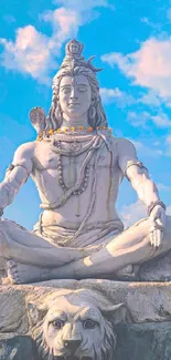 Serene statue of Lord Shiva under a blue cloudy sky.