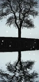 Serene silhouette of a tree with snowflakes and reflection.