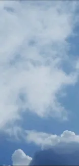 Blue sky with fluffy white clouds wallpaper.