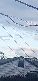 Serene view of sky with power lines and rooftop at dusk.