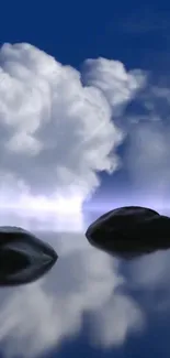 Serene blue sky with clouds and stones on reflective water surface.