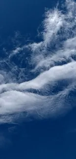 Serene blue sky with wispy white clouds.